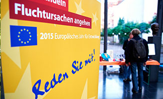 Plakat eines EU-Bürgerdialoges mit Personen im Hintergrund, die im Gespräch sind.