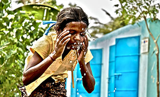 Ein Mädchen lässt sich Wasser über das Gesicht laufen. Foto: European Commission DG ECHO (flick_cc).