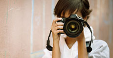 Eine Frau macht ein Foto. Die Kamera verdeckt das Gesicht. Foto: 123RF/kuzma