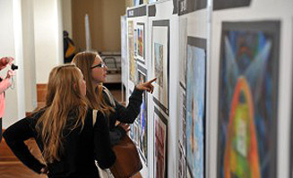 Zwei junge Frauen betrachten Ausstellungsbilder. Fotoquelle: Netzwerk EBD